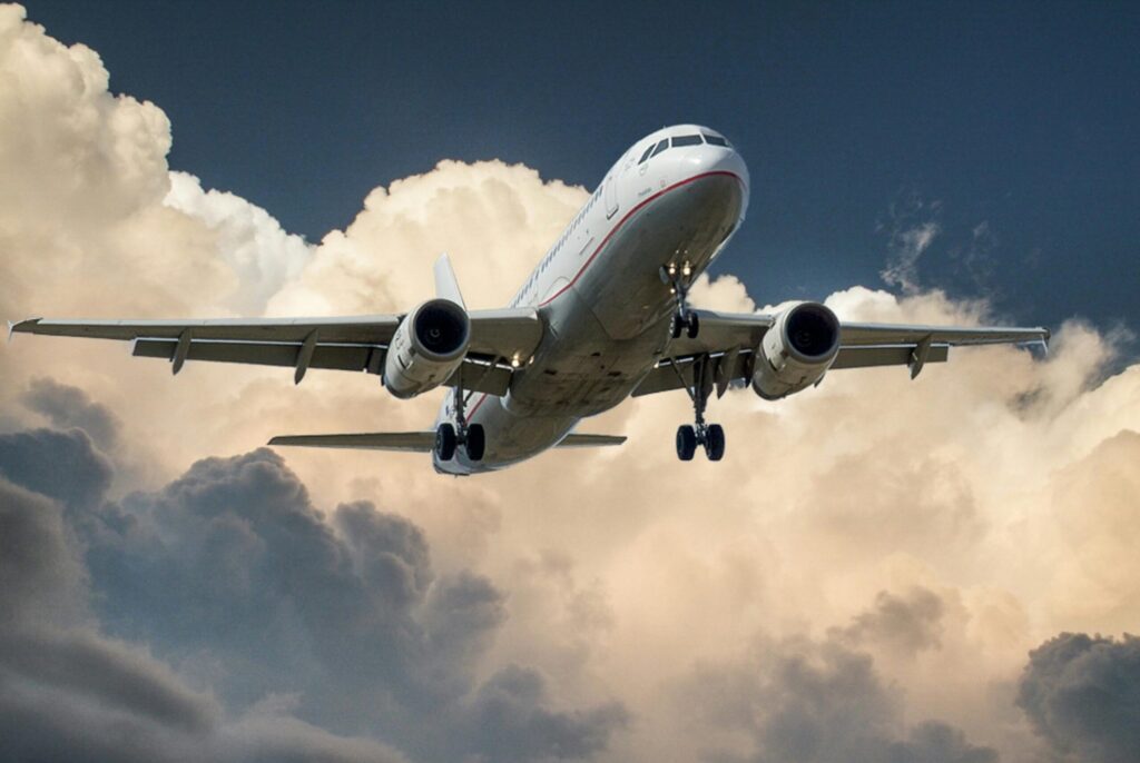 A commercial airplane flying through dramatic clouds, showcasing aviation in action.
