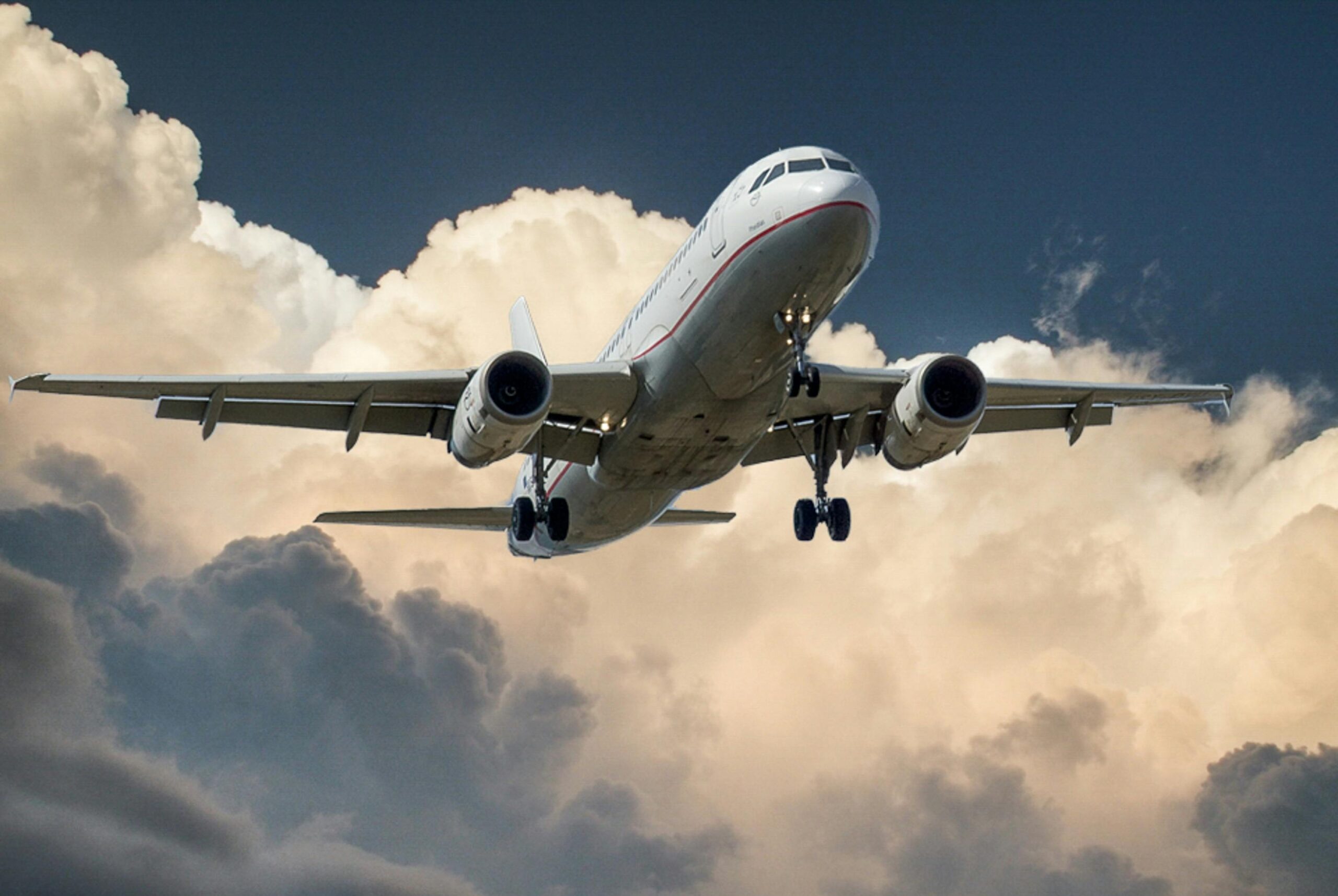 A commercial airplane flying through dramatic clouds, showcasing aviation in action.